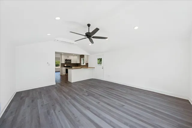a view of a kitchen with wooden floor and a ceiling fan