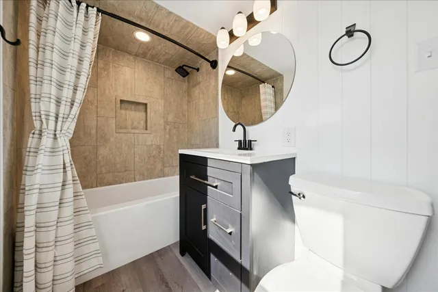 a bathroom with a sink a toilet a mirror and shower