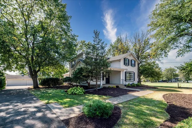 a front view of a house with a yard and tree s
