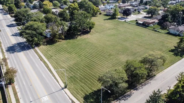 an aerial view of residential houses with outdoor space and trees