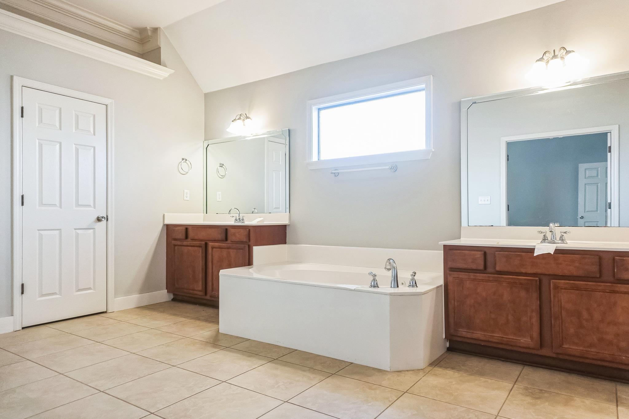 5225 Rockyford Road Bartlett, TN 38002 - Photo 13 of 18 Bathroom with a washtub, vanity, tile patterned floors, ornamental molding, and lofted ceiling