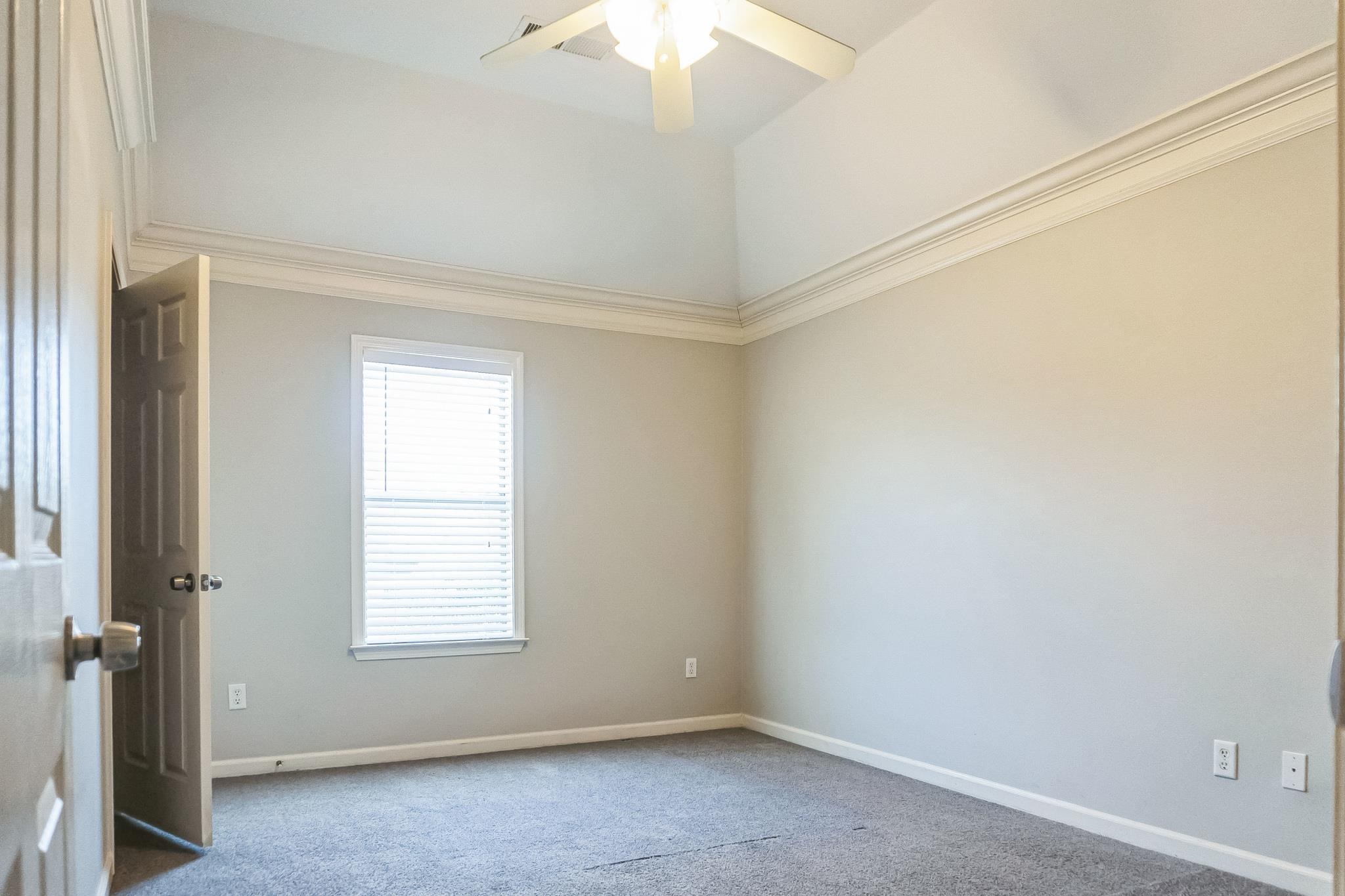 5225 Rockyford Road Bartlett, TN 38002 - Photo 14 of 18 Spare room featuring lofted ceiling, ceiling fan, crown molding, and carpet flooring