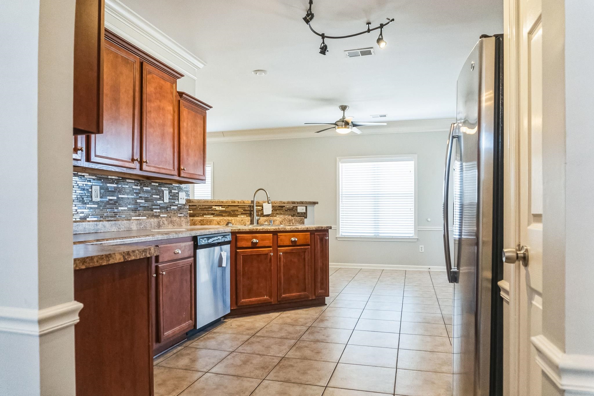 5225 Rockyford Road Bartlett, TN 38002 - Photo 8 of 18 Kitchen featuring stainless steel appliances, ceiling fan, backsplash, and crown molding