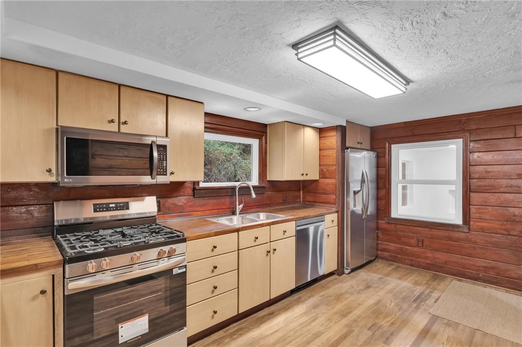 155 Harrold Street Jeannette, PA 15644 - Photo 16 of 37 a kitchen with stainless steel appliances a stove sink and cabinets