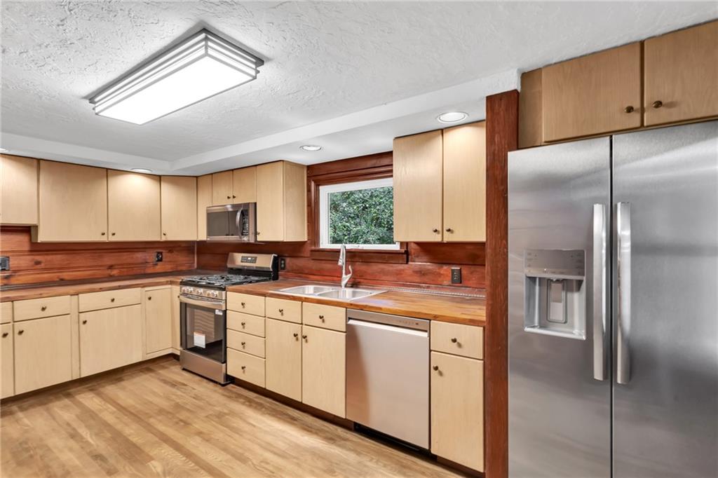 155 Harrold Street Jeannette, PA 15644 - Photo 20 of 37 a kitchen with a sink stainless steel appliances cabinets and a window
