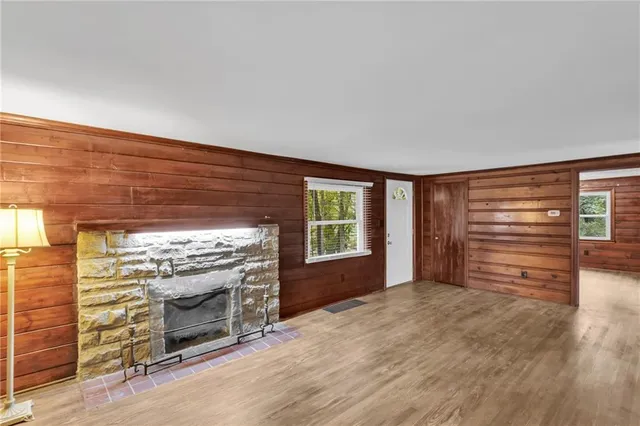a view of an empty room with a fireplace and a window