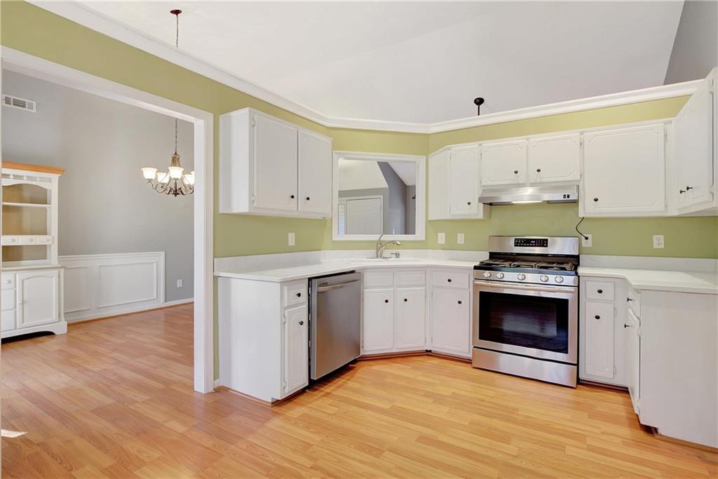 7 Buck Trail Newnan, GA 30265 - Photo 11 of 37 a kitchen with granite countertop a stove a sink and a refrigerator