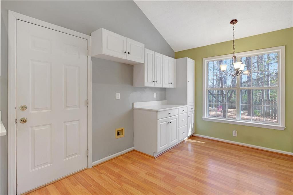 7 Buck Trail Newnan, GA 30265 - Photo 14 of 37 a kitchen with white cabinets and wooden floors