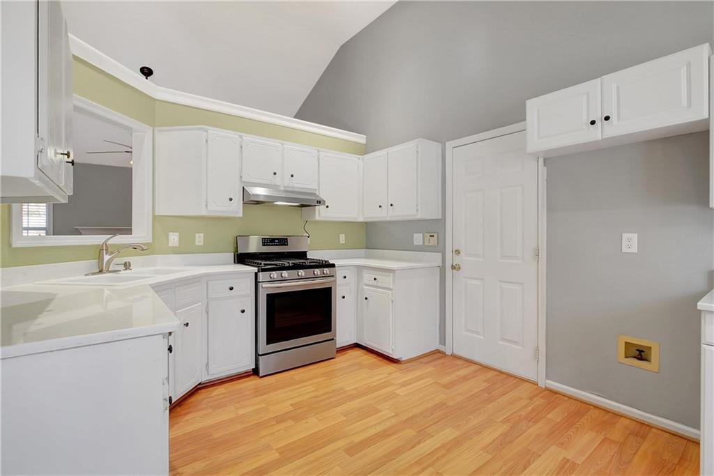 7 Buck Trail Newnan, GA 30265 - Photo 10 of 37 a kitchen with a sink white cabinets and white appliances