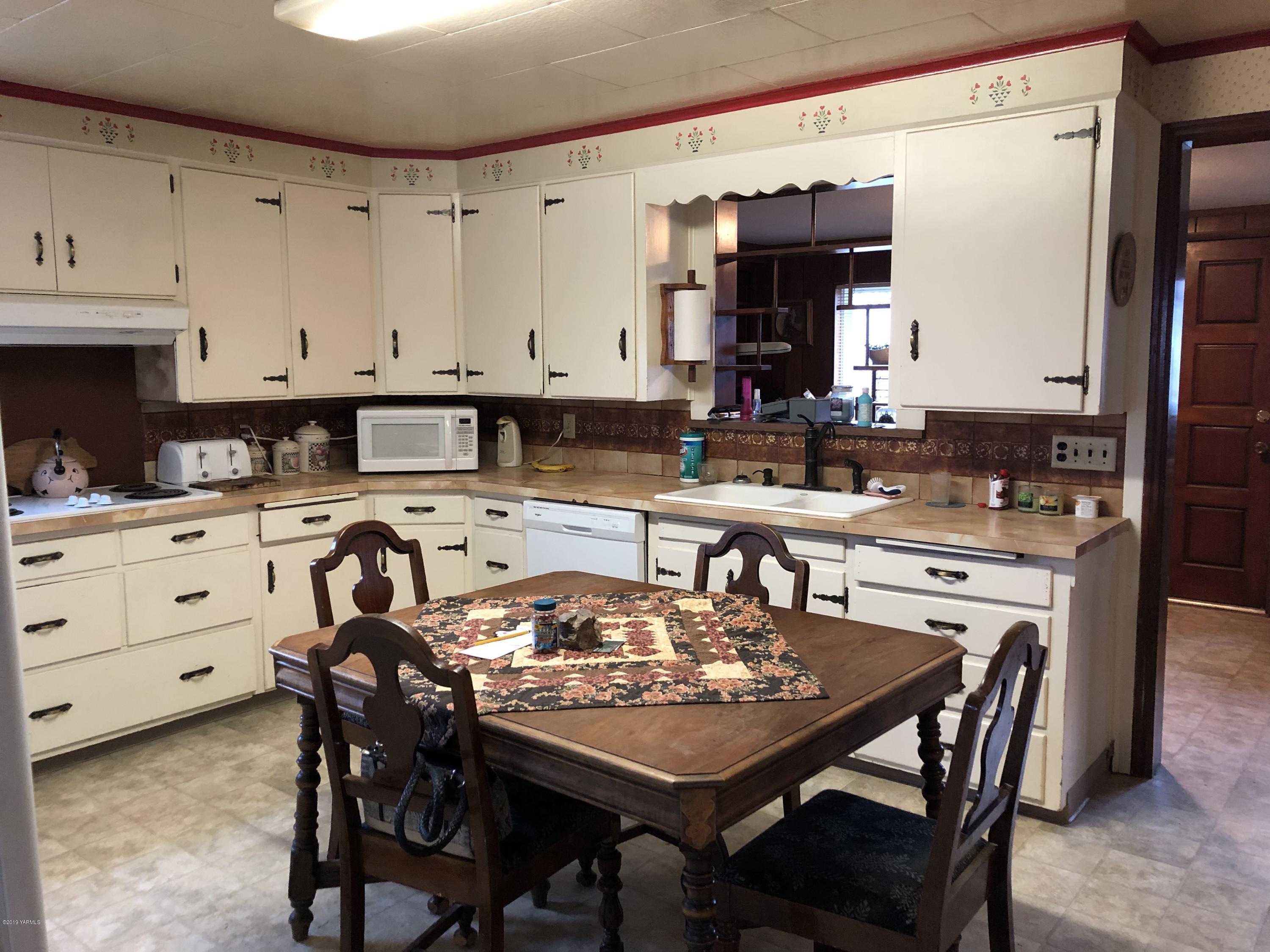 1152 South Rivard Road Moxee, WA 98936 - Photo 25 of 46 a kitchen with a table chairs and white cabinets