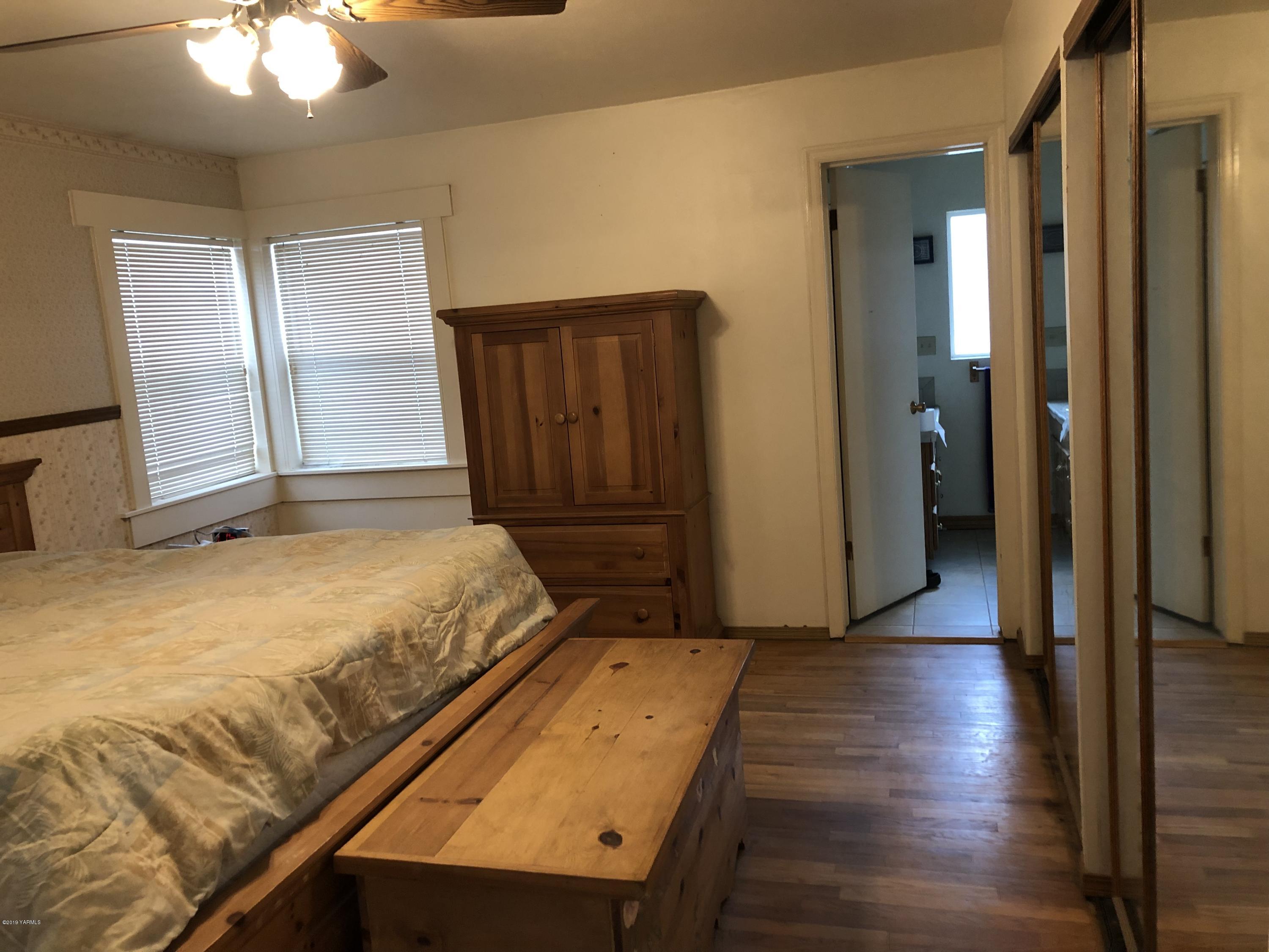 1152 South Rivard Road Moxee, WA 98936 - Photo 30 of 46 a bedroom with a bed and a chandelier