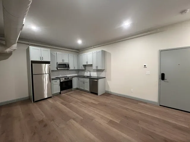 a kitchen with stainless steel appliances granite countertop a refrigerator and a stove top oven