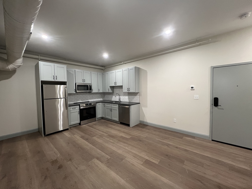 160 Seabury Street, Unit 4 Fall River, MA 02720 - Photo 2 of 10 a kitchen with stainless steel appliances granite countertop a refrigerator and a stove top oven