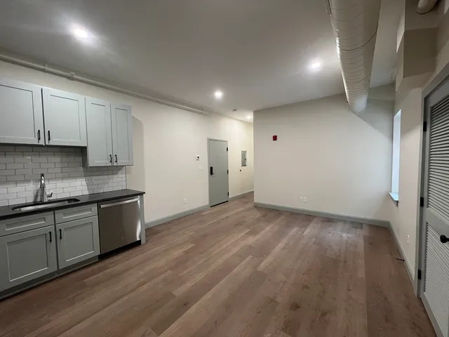 a kitchen with a sink and wooden floor