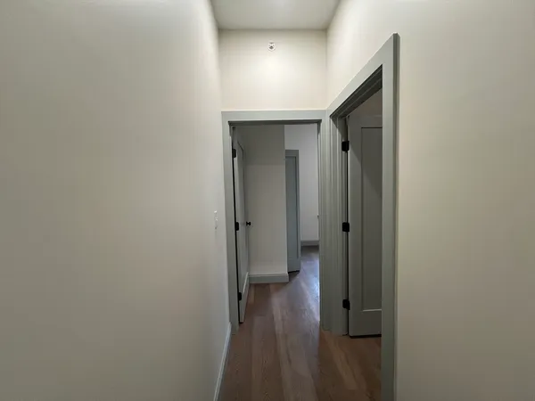 a view of a hallway with wooden floor