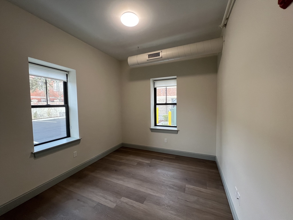 160 Seabury Street, Unit 4 Fall River, MA 02720 - Photo 6 of 10 an empty room with wooden floor and windows