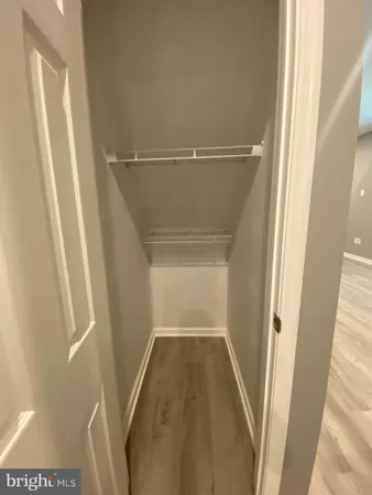 a view of walk in closet with wooden floor