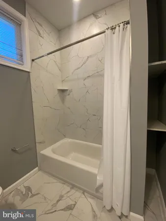 a bathroom with a shower and a bath tub