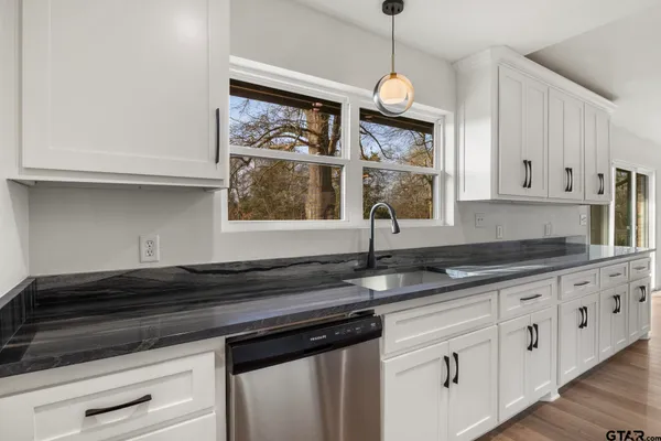 a kitchen with stainless steel appliances granite countertop a stove a microwave and a refrigerator