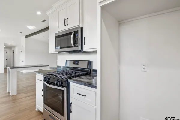 a large kitchen with stainless steel appliances granite countertop a stove and a sink