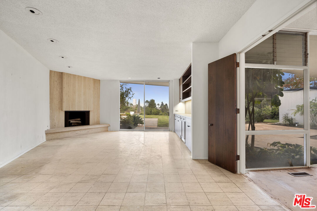 938 North Alpine Drive Beverly Hills, CA 90210 - Photo 8 of 11 a view of a livingroom with a fireplace and a couch