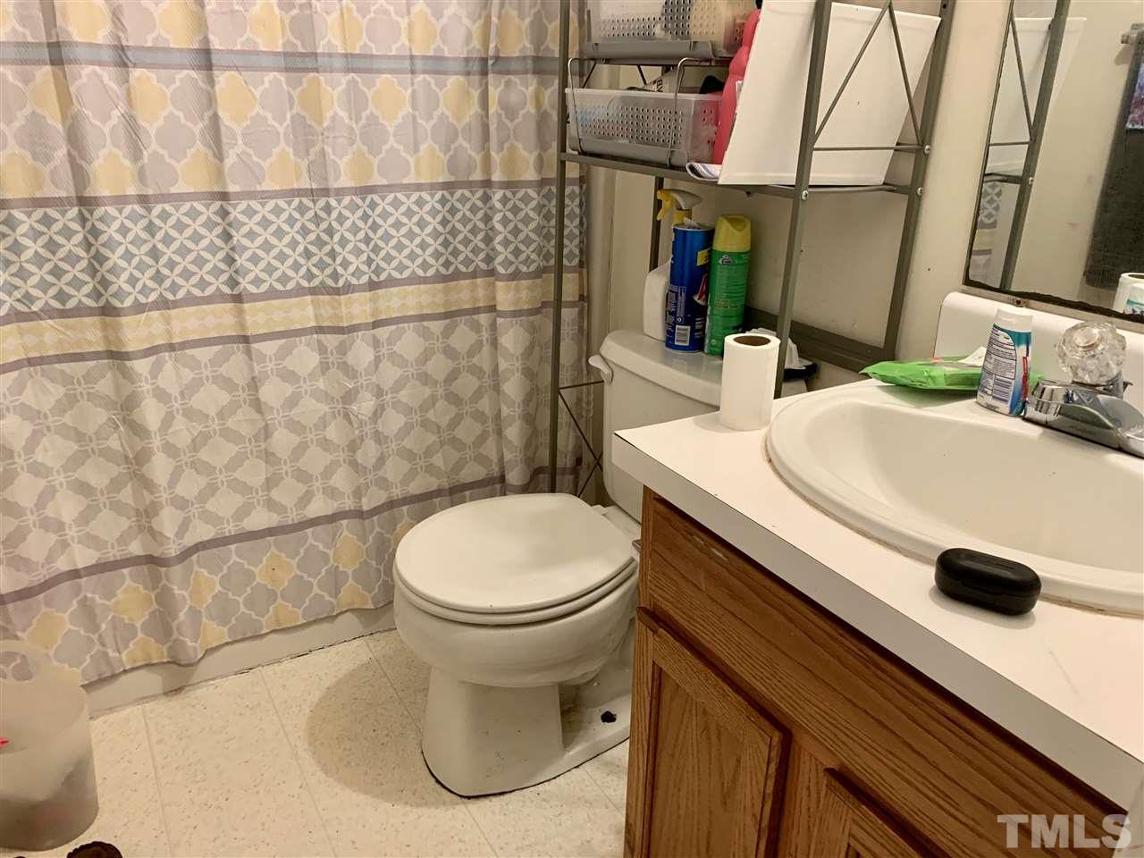5121 Vann Street Raleigh, NC 27606 - Photo 9 of 12 a bathroom with a sink a toilet and shower