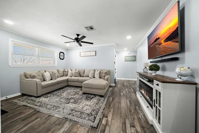 a living room with furniture a flat screen tv and a fireplace