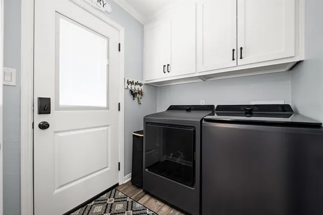 a bedroom with a bed couch chandelier and a window