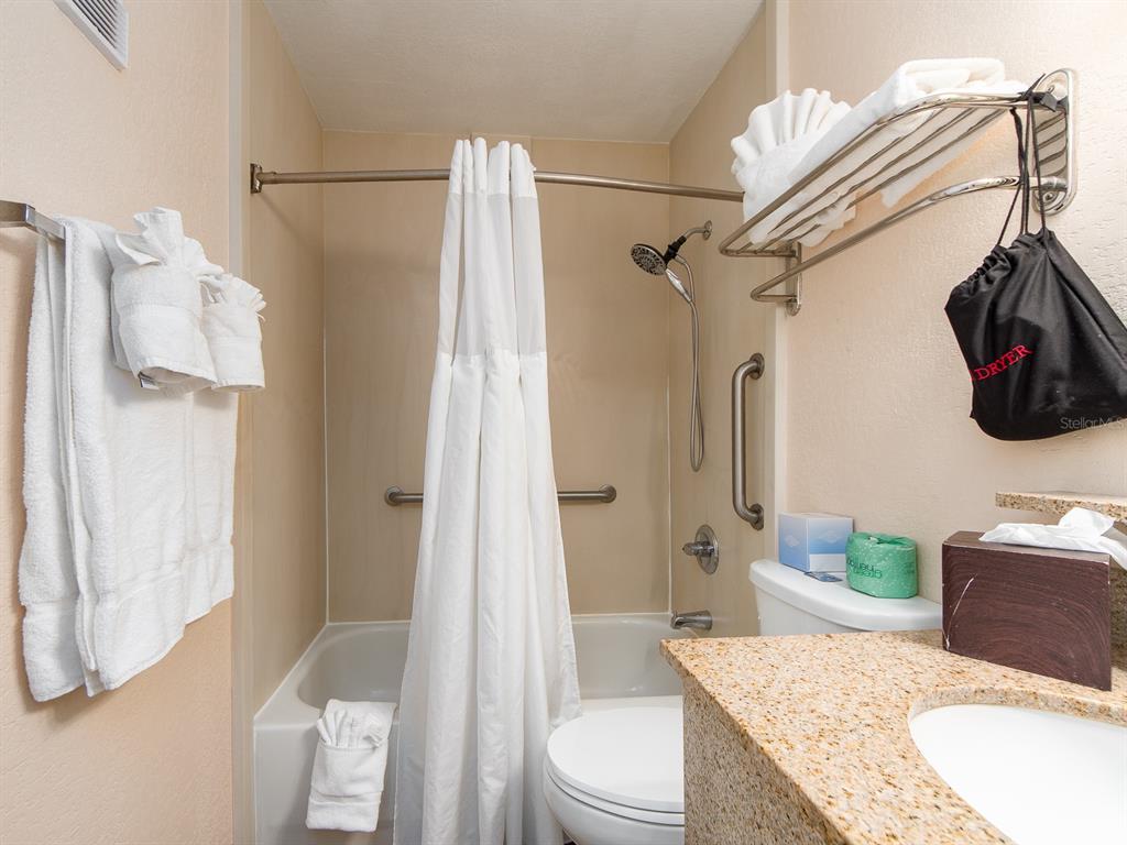 2506 North Rocky Point Drive, Unit 358 Tampa, FL 33607 - Photo 16 of 45 a bathroom with a granite countertop sink toilet and shower