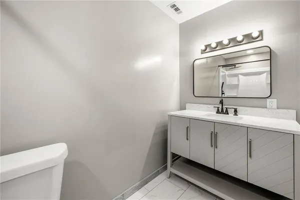 a bathroom with a sink a toilet and mirror