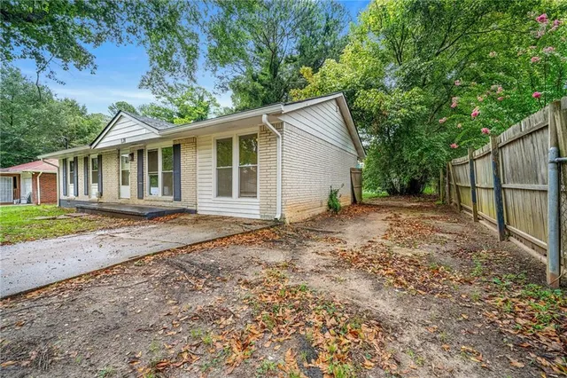a view of a yard in front of a house with large trees