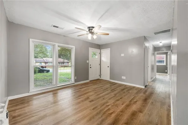 a view of an empty room with glass door and a window