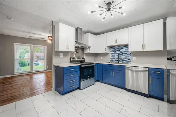 a kitchen with stainless steel appliances granite countertop a stove a sink dishwasher and a refrigerator