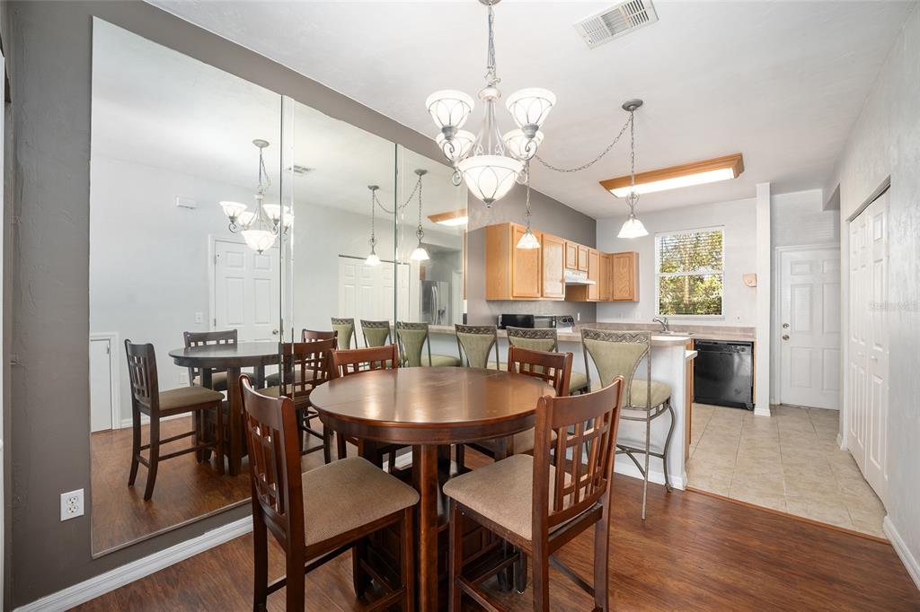 3910 Southwest 20th Avenue, Unit 1403 Gainesville, FL 32607 - Photo 12 of 36 a dining room with wooden floor a chandelier a wooden table and chairs