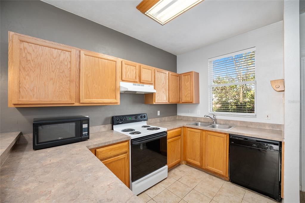 3910 Southwest 20th Avenue, Unit 1403 Gainesville, FL 32607 - Photo 15 of 36 a kitchen with stainless steel appliances granite countertop a stove sink and cabinets