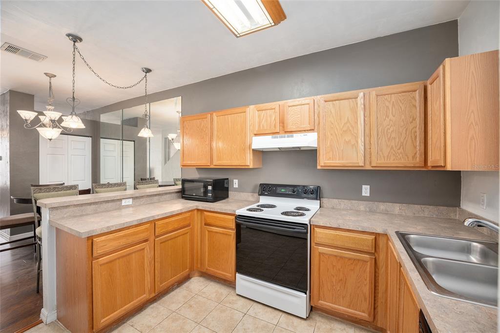 3910 Southwest 20th Avenue, Unit 1403 Gainesville, FL 32607 - Photo 16 of 36 a kitchen with a sink stove and cabinets