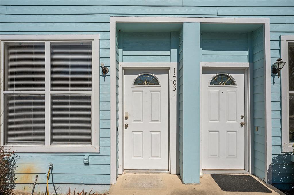3910 Southwest 20th Avenue, Unit 1403 Gainesville, FL 32607 - Photo 5 of 36 a front view of a house with a glass door and a window