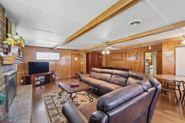 a living room with furniture a flat screen tv and a floor to ceiling window