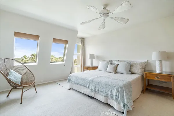 a bedroom with a bed a chair and a chandelier