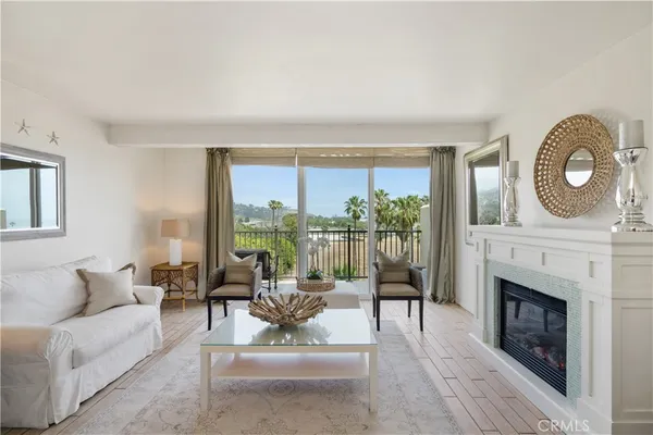 a living room with furniture a large window and a fireplace