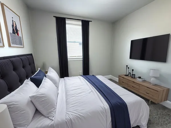 a bedroom with a bed and a flat screen tv