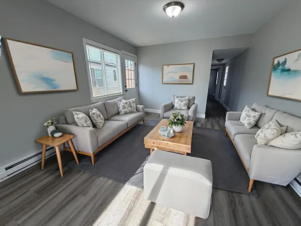 a living room with furniture and a wooden floor