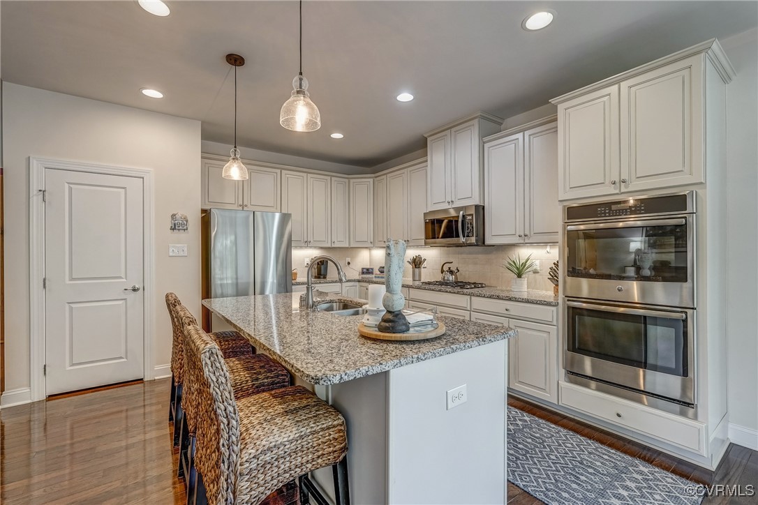 13119 Rodington Court Midlothian, VA 23113 - Photo 18 of 48 a kitchen with stainless steel appliances granite countertop a stove a refrigerator a microwave a sink and white cabinets with wooden floors
