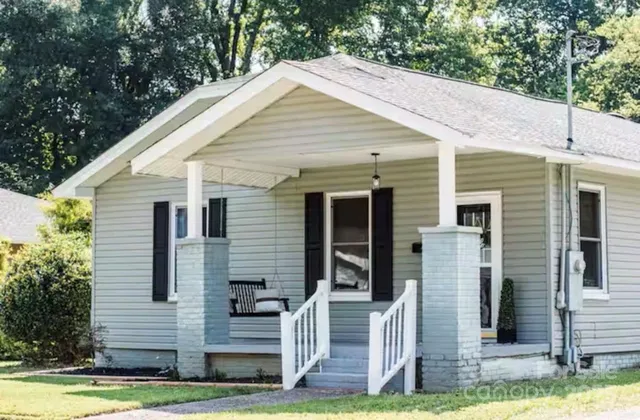 a view of a white house with tree s