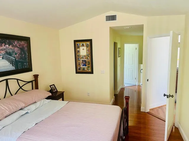 a bedroom with a bed and wooden floor