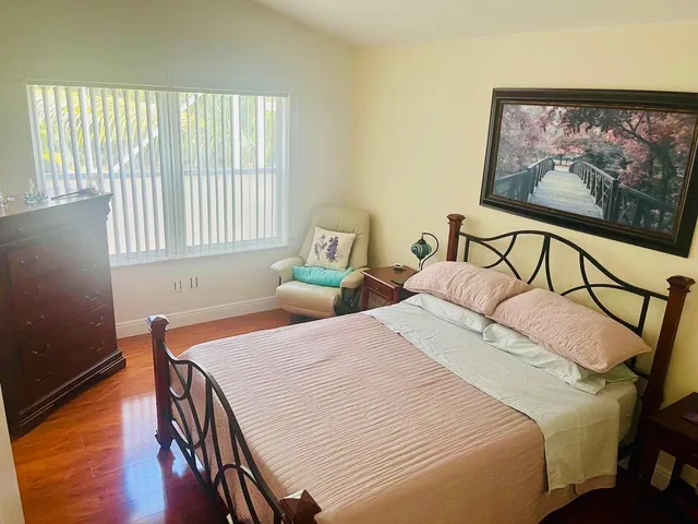 a bedroom with bed and wooden floor
