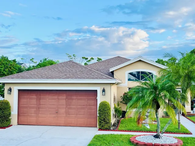 front view of house with a yard and potted plants