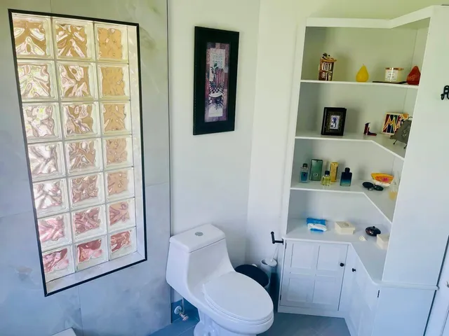 a white toilet sitting next to a bathroom sink and vanity