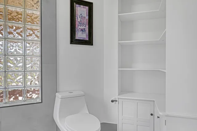 an empty room with wooden floor closet and ceiling fan
