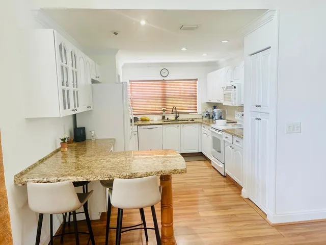a kitchen with stainless steel appliances granite countertop a kitchen island a stove a table and chairs in it